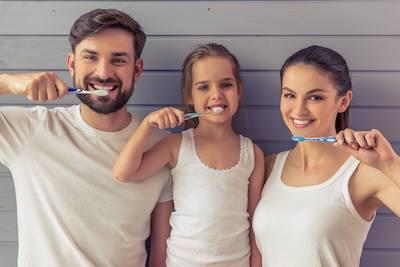 Happy family brushing their teeth