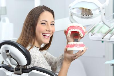 Woman holding illustration of the teeth