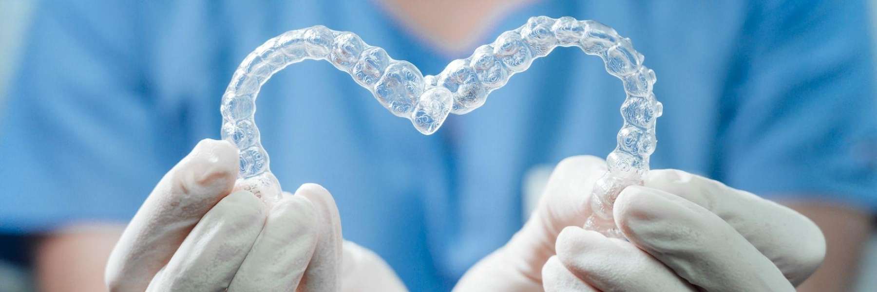 dentist holding 2 Invisaligns forming a heart