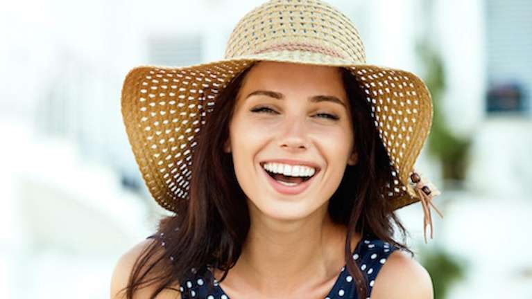 Woman wearing brown hat while smiling